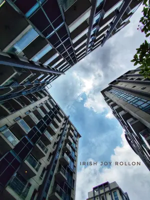 two tall buildings looking up at the sky between them at Condotel Near Naia Terminal 3 in Manila