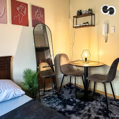 a room with a table and two chairs and a bed at Sunshine 100 Stylish Condo by The Capital Cabin in Manila