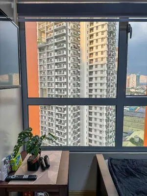 a window with a view of a tall building at Sunshine 100 Stylish Condo by The Capital Cabin in Manila