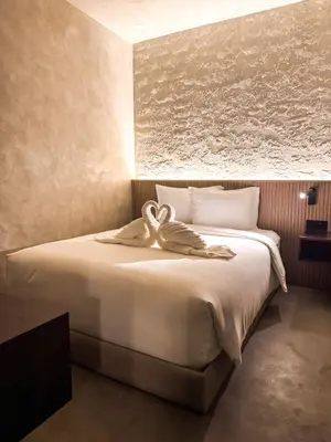 a bedroom with a large bed with a towel on it at Yamato Hostel in Manila