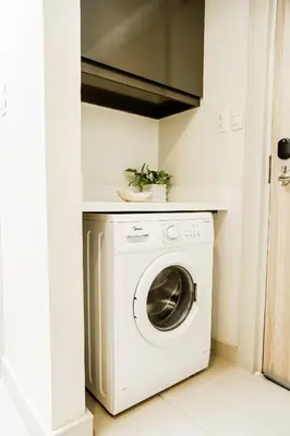 a laundry room with a washer and dryer at Luxe Suite at BCCT - BGC's Prime Studio - Gym, Infinity Pool with breathtaking skyline view in Manila