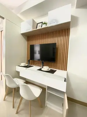 a living room with a white desk and two chairs at south residences in Manila