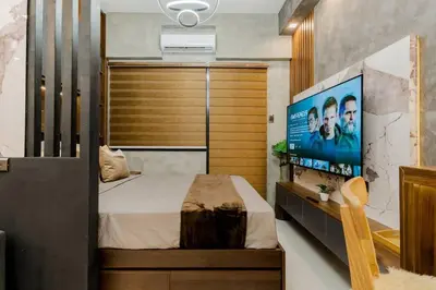 a bedroom with a bed and a flat screen tv at 1BR Makati, Lush Residences M004 in Manila