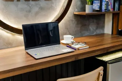 a laptop computer sitting on top of a wooden desk at 1BR Makati, Lush Residences M004 in Manila
