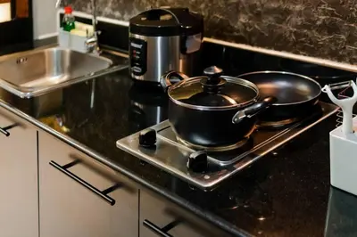 two pots and pans sitting on a stove in a kitchen at 1BR Makati, Lush Residences M004 in Manila
