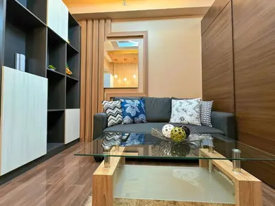 a living room with a couch and a glass table at 1BR Makati, Air Residences M005 in Manila