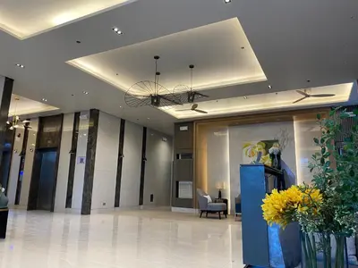 a lobby of a building with a chair and flowers at Cozy Blossom near NAIA in Manila
