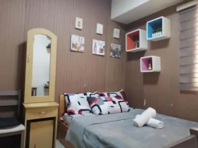 a bedroom with a bed and a dresser and a mirror at pierrecondotel in Manila