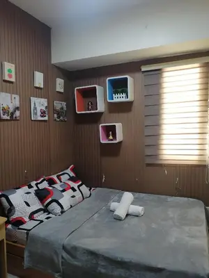a bedroom with a large bed and a window at pierrecondotel in Manila