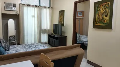 a living room with a bed and a television at 1 bedroom Condotel in front of terminal 3 Airport in Manila
