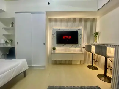 a bedroom with a bed and a tv on a wall at B & M Condo near NAIA Airport and SM Mall in Manila