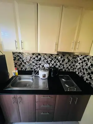 a kitchen with a sink and a counter top at vevilyn condotel in Manila