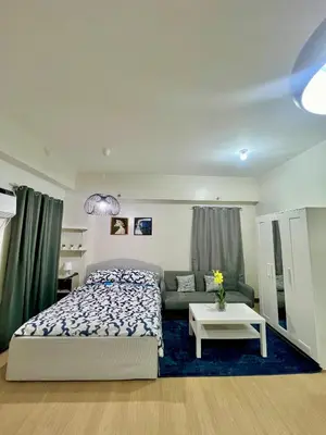 a bedroom with a bed and a couch at Glade Suite in Trece Martires