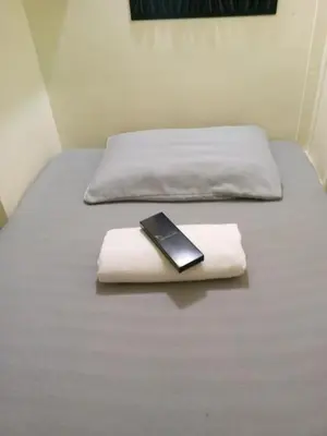 a cell phone sitting on top of two beds at RDC- Baclaran Transient Capsule in Manila