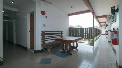 a wooden bench in a room with a balcony at RedDoorz at Joels Apartelle in Calaboso