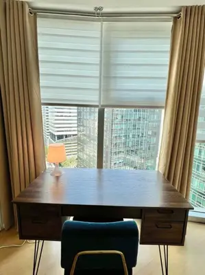 a wooden table with a lamp in front of a window at Charming 3-BR Condo in BGC in Manila