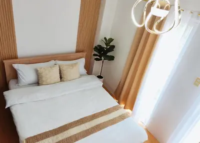 a bedroom with a bed with a chandelier and a window at Paradise Realm Condotel in Manila