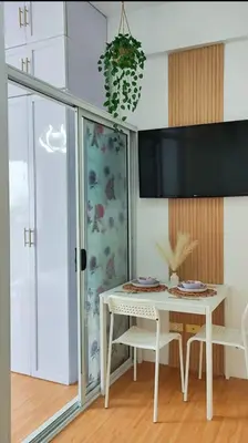 a dining room with a white table and chairs at Paradise Realm Condotel in Manila