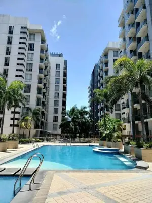a swimming pool in the middle of two tall buildings at ONE PALM TREE VILLAS-Hyuna Place, Acros NAIA T3 in Manila