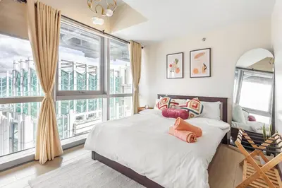 a bedroom with a bed and a large window at Executive 1 Bedroom with Pool Sauna Gym and More in Manila