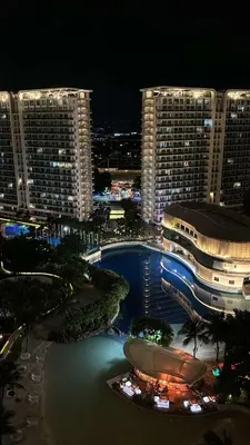a view of a city at night with a pool at AZURE Urban Resort Residences Paranaque City in Manila