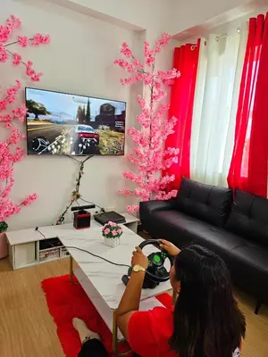 a woman playing a video game in a living room at Lakwatsero Caviteño Suites in Trece Martires