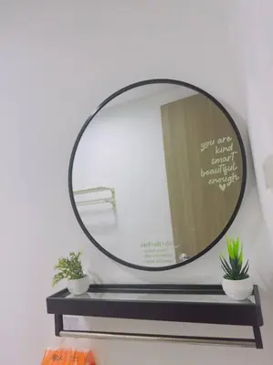 a mirror on a wall with two plants on a shelf at Zenrise Staycation Condo in SMDC Hope Residences Trece Martires in San Agustin