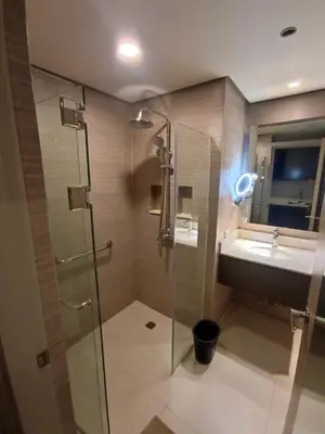 a bathroom with a glass shower and a sink at GBA Condotel at Bonifacio Civic Center Tower in Manila