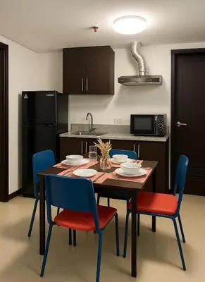 a kitchen with a wooden table and chairs and a kitchen with a kitchen at Kasara Urban Resort & Residences in Manila