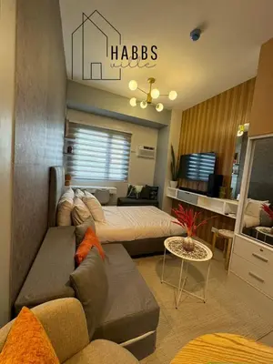 a living room with a couch and a bed at HabbsVille at Green 2 Residences by SMDC Dasmarinas Cavite in Dasmariñas