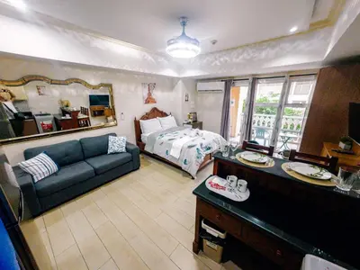 a living room with a bed and a blue couch at COZI Venice Luxury Residences Alessandro BGC w Pool Gym in Manila