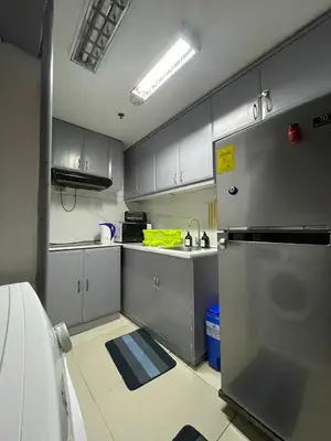 a kitchen with gray cabinets and a stainless steel refrigerator at 1BR Condotel - Forbes Town Road near St Lukes BGC Taguig in Manila