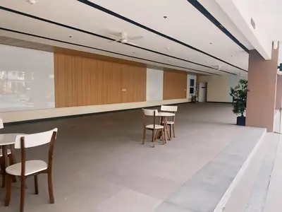 an empty room with tables and chairs in a building at Anne's Place at Hope Residences - SMDC Condo Beside SM Trece in Trece Martires