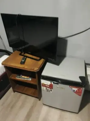 a flat screen tv sitting on top of a table at Slouch Hat Hotel and Restaurant in Manila