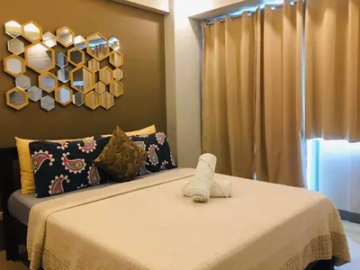 a bedroom with a bed with a stuffed animal on it at Two Palm Tree Condotel in Manila
