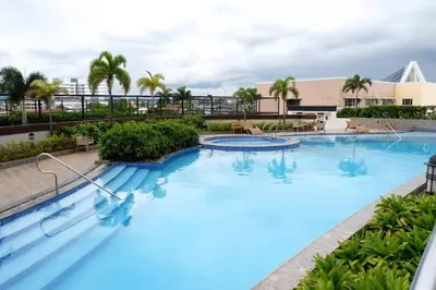 a large pool with blue water in a resort at Modern Nordic 1 Bedroom Condo near Eastwood, Quezon City in Manila