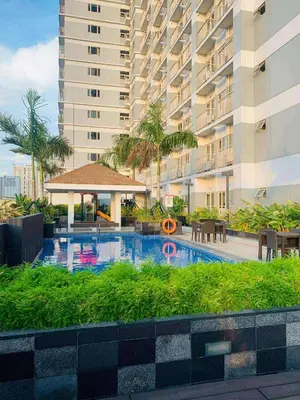 a swimming pool in front of a large building at Cozy Easy Escape in Manila