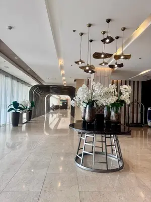 a lobby with a table with vases of flowers on it at Staycation At Shore by LAYANDY in Manila