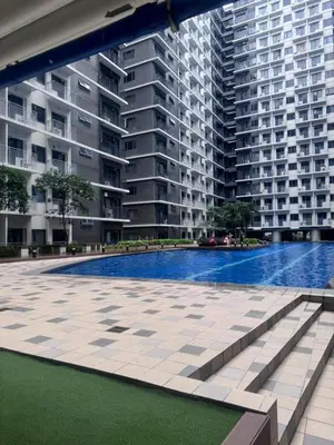 a swimming pool in front of a large apartment building at Staycation At Shore by LAYANDY in Manila
