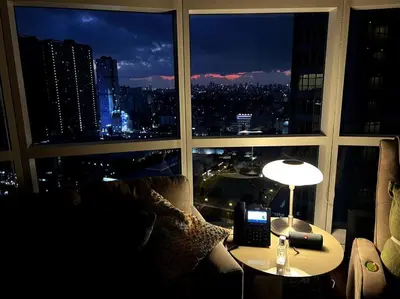 a living room with a view of a city at night at 1BR Premium condo - Twin Oaks Pl PANORAMIC VIEW in Manila