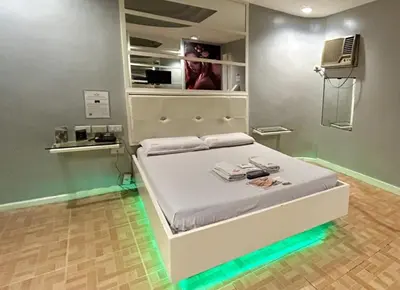 a bedroom with a bed with lights on it at Town and Country Reposo in Manila
