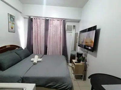 a bedroom with a bed with a teddy bear on it at pierrecondotel in Manila