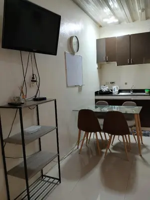 a kitchen with a table and chairs and a television at Kassel DORZ Hostel Bldg 16 Condostaycation in Manila