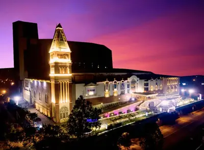 a large building with a clock tower at night at Luxury Apartment with PA, Skyline View & Top Amenities in Manila