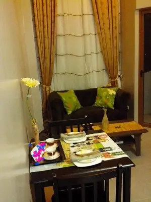 a living room with a table and a couch at Monteluce Condominium Apartment in Silang