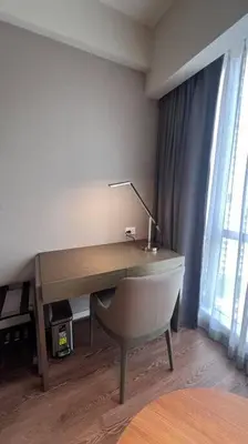 a desk with a chair and a lamp in a room at Staycation at ACQUA The Hotel Residences Novotel Tower in Manila
