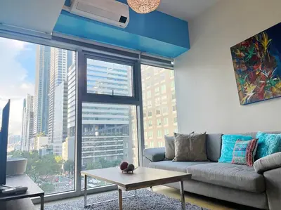 a living room with a couch and a large window at Marina- Avant BGC parking w fee in Manila