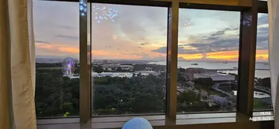 a view of a sunset from a window at Serenity by Zen Residences at The Radiance Manila Bay in Manila