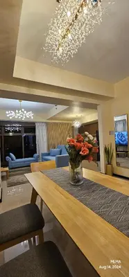 a living room with a table with a vase of flowers at Serenity by Zen Residences at The Radiance Manila Bay in Manila