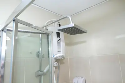 a shower in a bathroom with a shower head at Nordic Place Fame Residences 75 Smart Amenities Alexa 200mbps Wifi Netflix in Manila